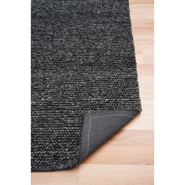 Dark gray textured rug on a wooden floor