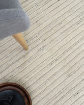 Focusing on the fine handloom-knotted details, illustrating the skilled artistry and quality of the 100% wool composition.