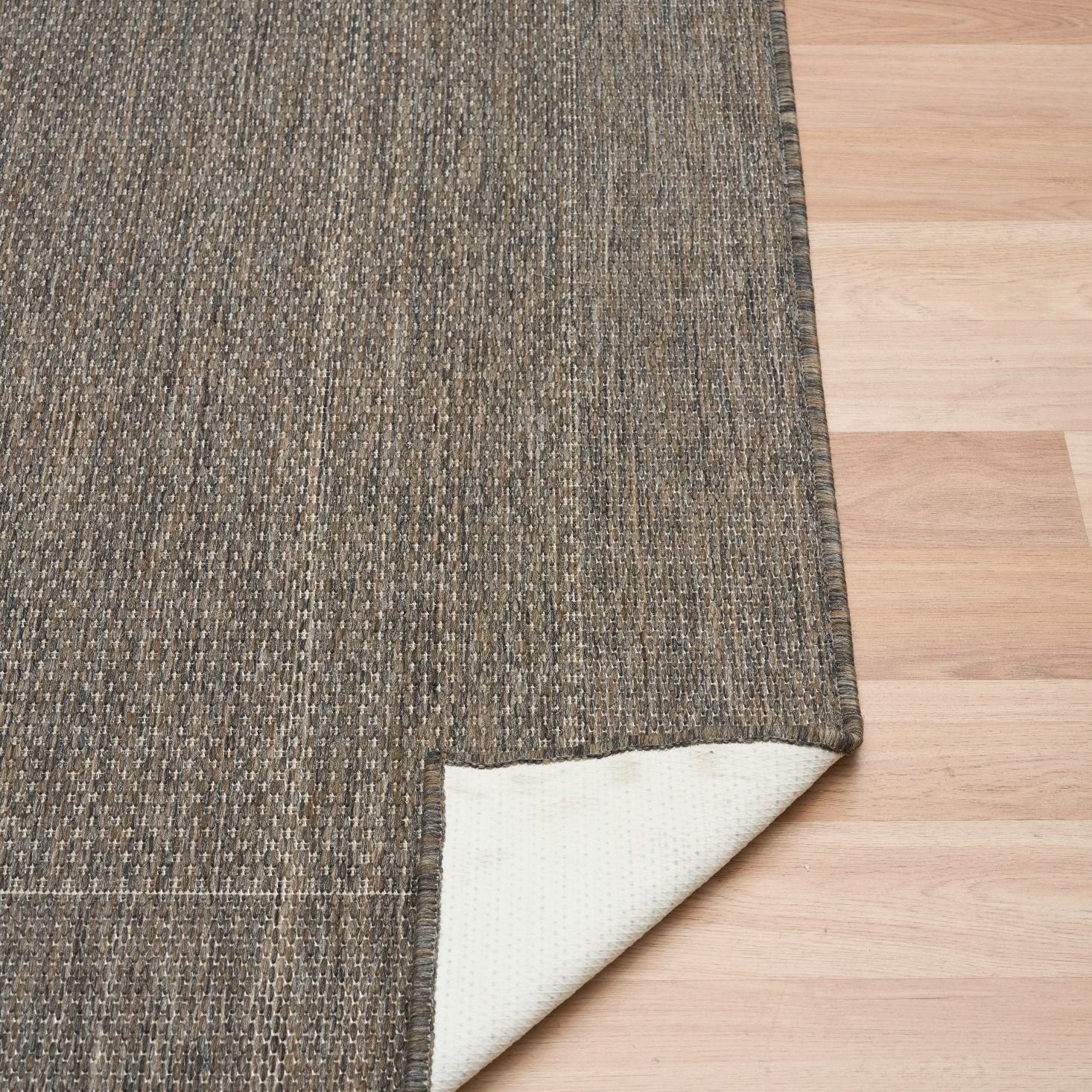 Chino rug showing its latex backing on a timber floor