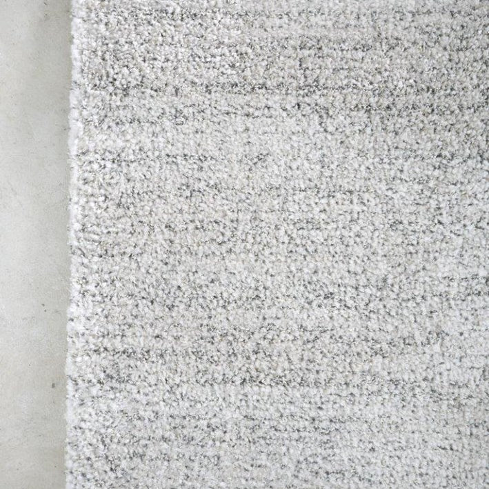 Textured gray rug on a concrete floor