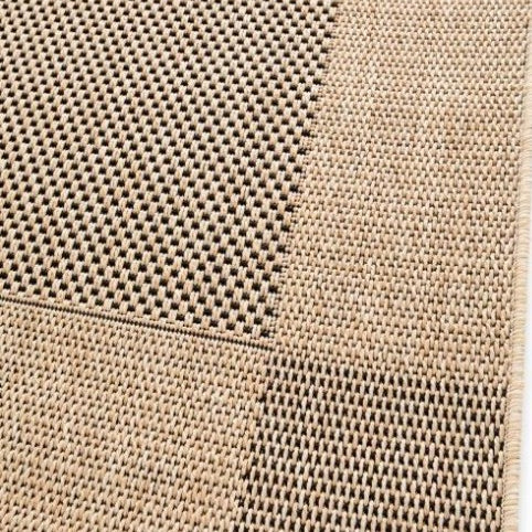 Close-up of a textured beige rug with a grid pattern on a white background