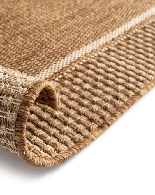 Close-up of a brown textured rug corner on a white background