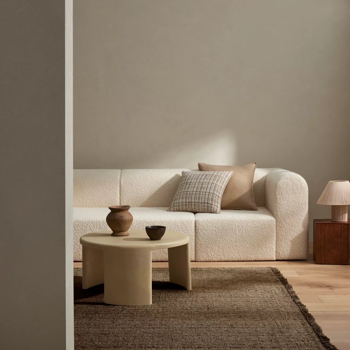 Modern living room with a beige sofa, coffee table, and decorative items.