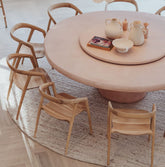 Round wooden dining table with chairs in a room setting
