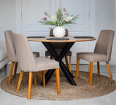 Dining table with four chairs and a vase of flowers in a room.