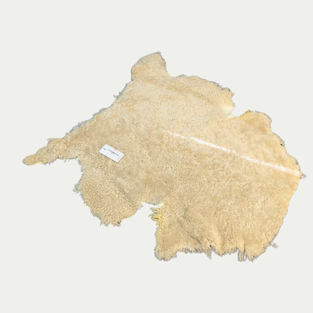 Beige sheepskin rug on a white background