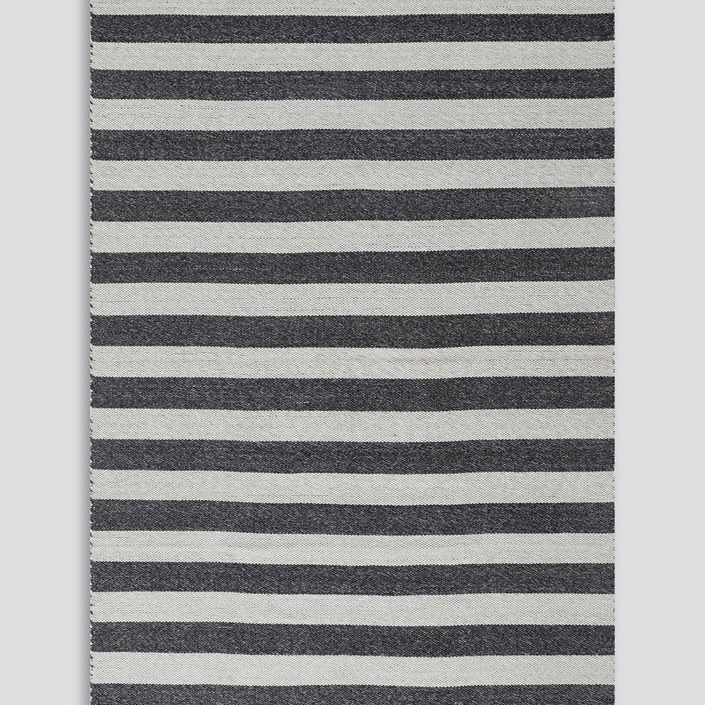A rectangular woven rug with horizontal stripes in dark charcoal gray and off-white, finished with fringed edges on all sides, shown flat against a light gray background.