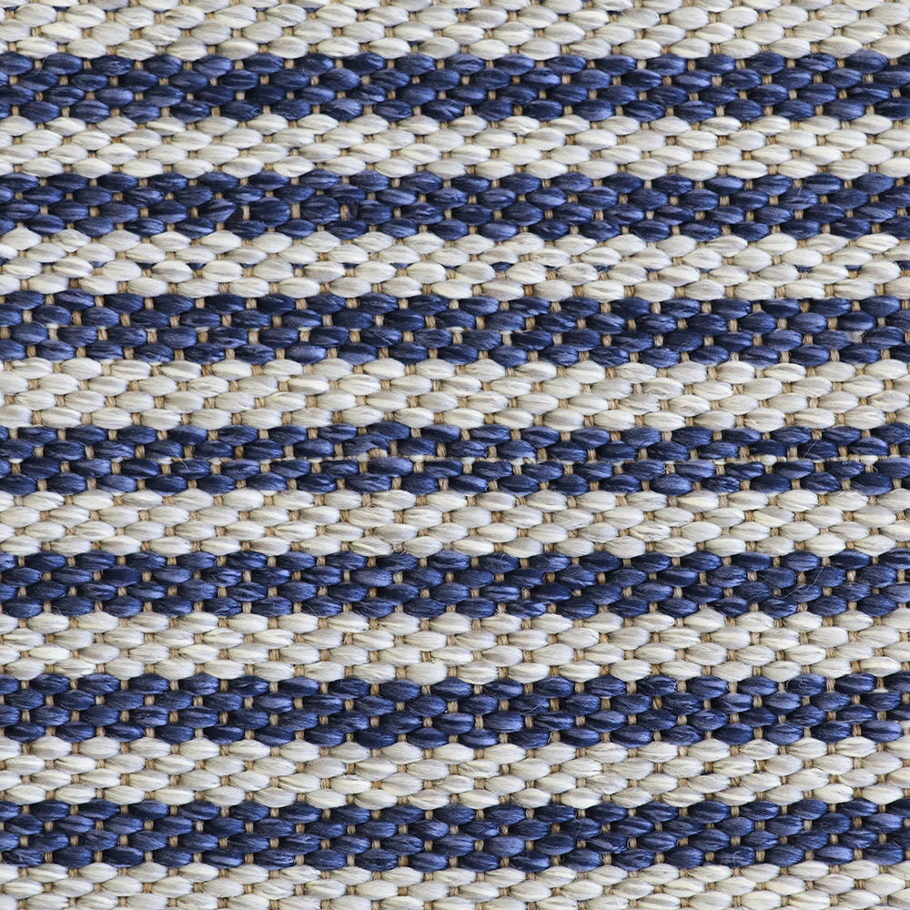 A close-up of a woven textile with horizontal stripes in navy blue and warm off-white, showing the detailed texture of the fibers.