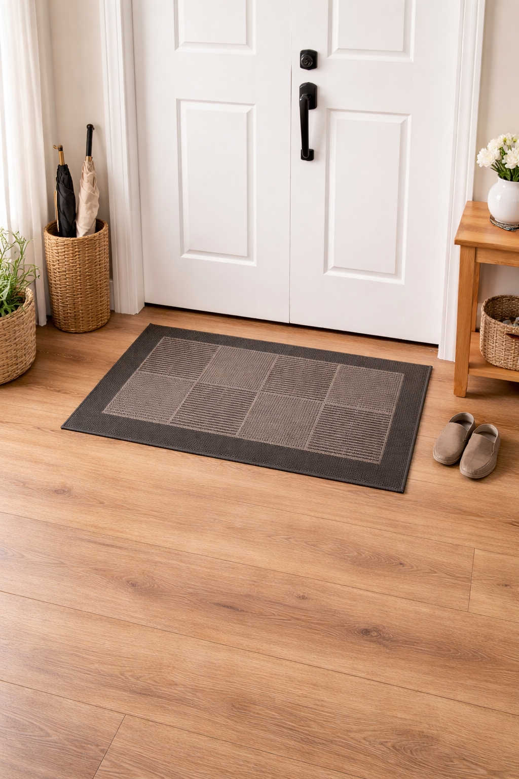 Gray doormat in front of a white door with shoes and baskets on a wooden floor.