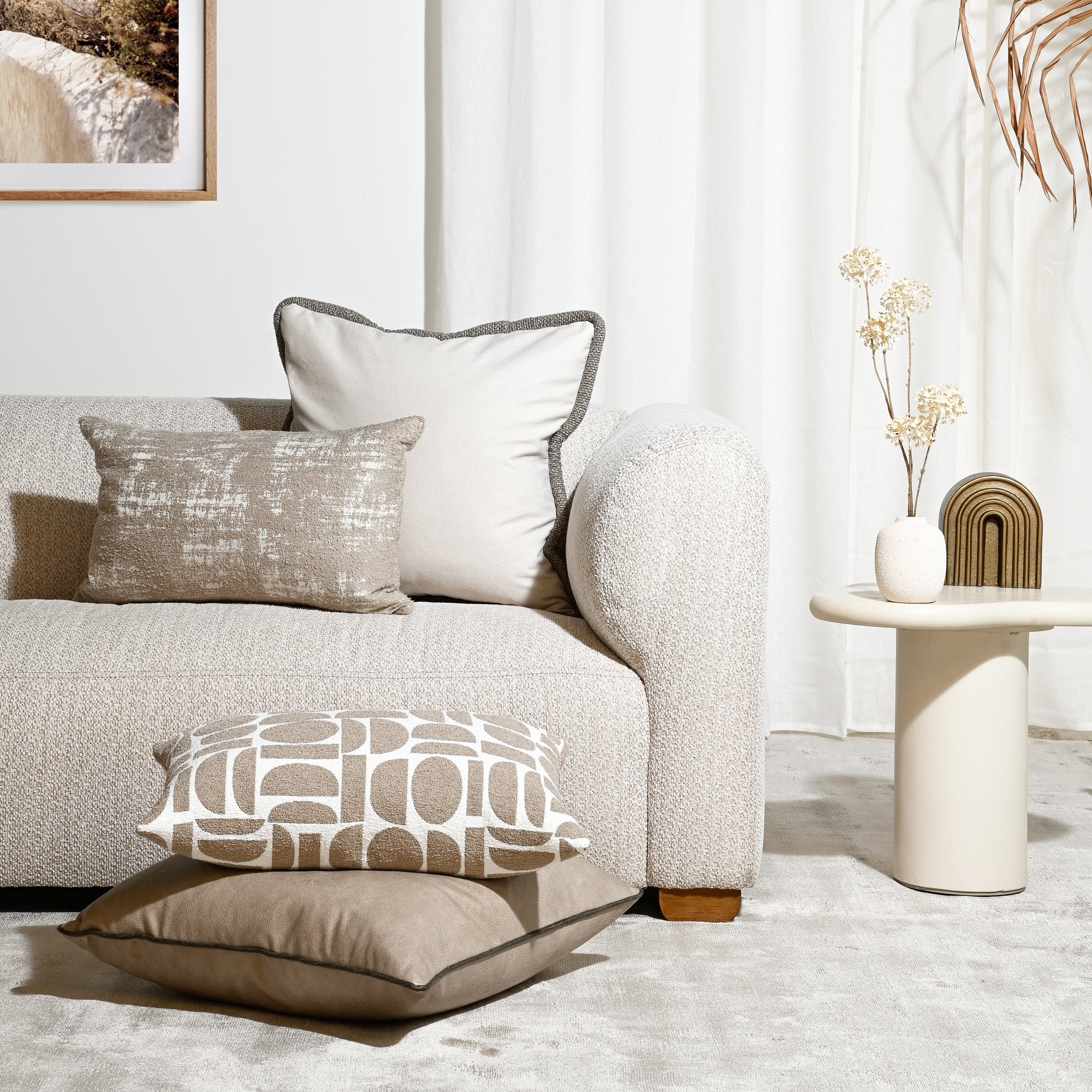 Beige sofa with decorative pillows in a modern living room setting