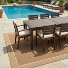 Outdoor patio set with table and chairs by a pool