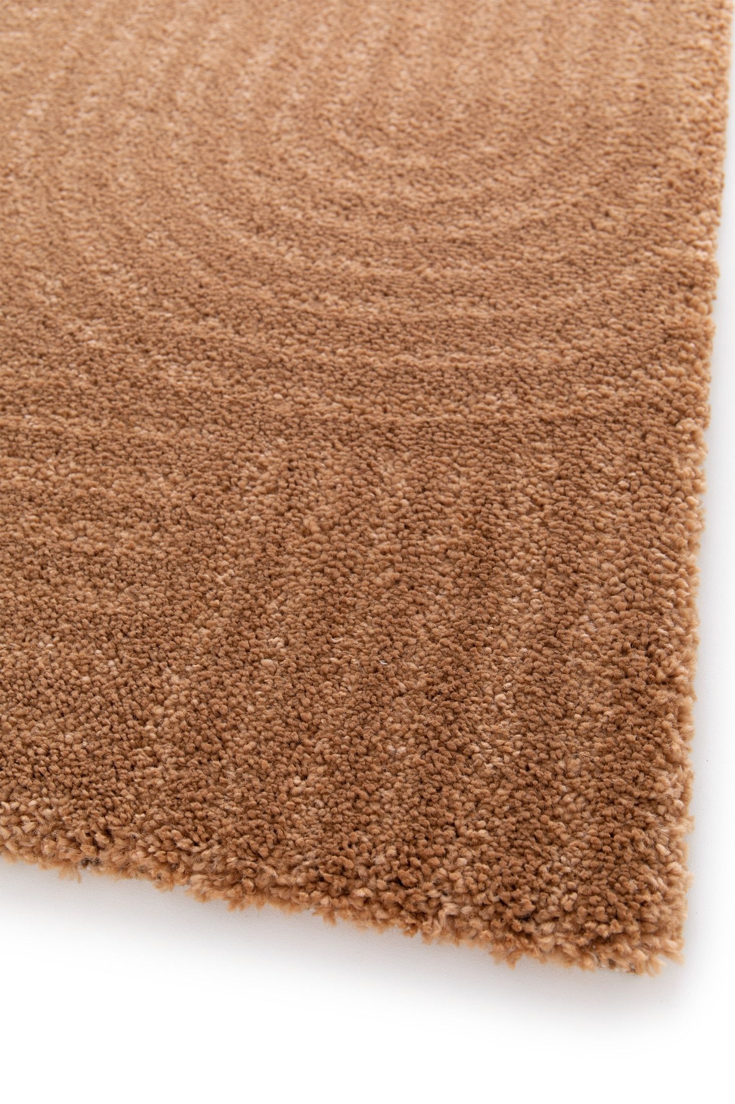 Close-up of a brown textured rug corner on a white background