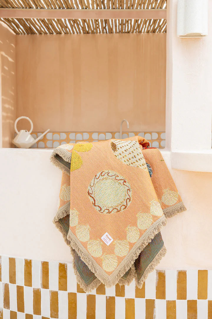 Decorative throw blanket with geometric pattern on a couch in a cozy living room.