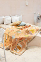 Children's room with a bed covered by a colorful blanket featuring cartoon animals.