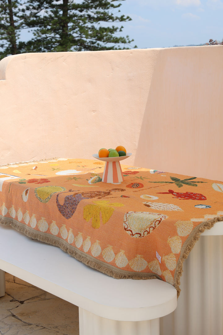 Decorative tablecloth with floral patterns on a white table outdoors.