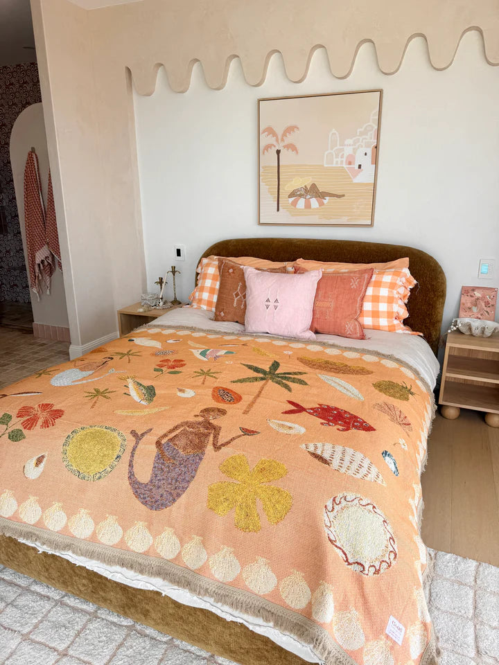 Bedroom with a bed featuring a colorful quilt and pillows, decorated with a wall art piece.