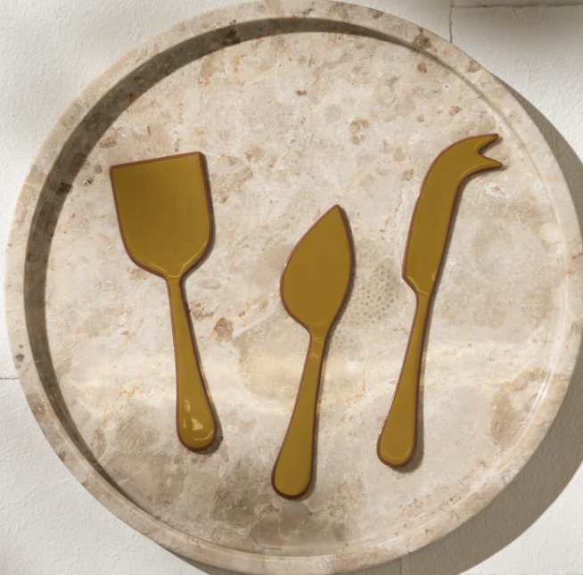 Decorative stone tray with gold cutlery icons on a light background