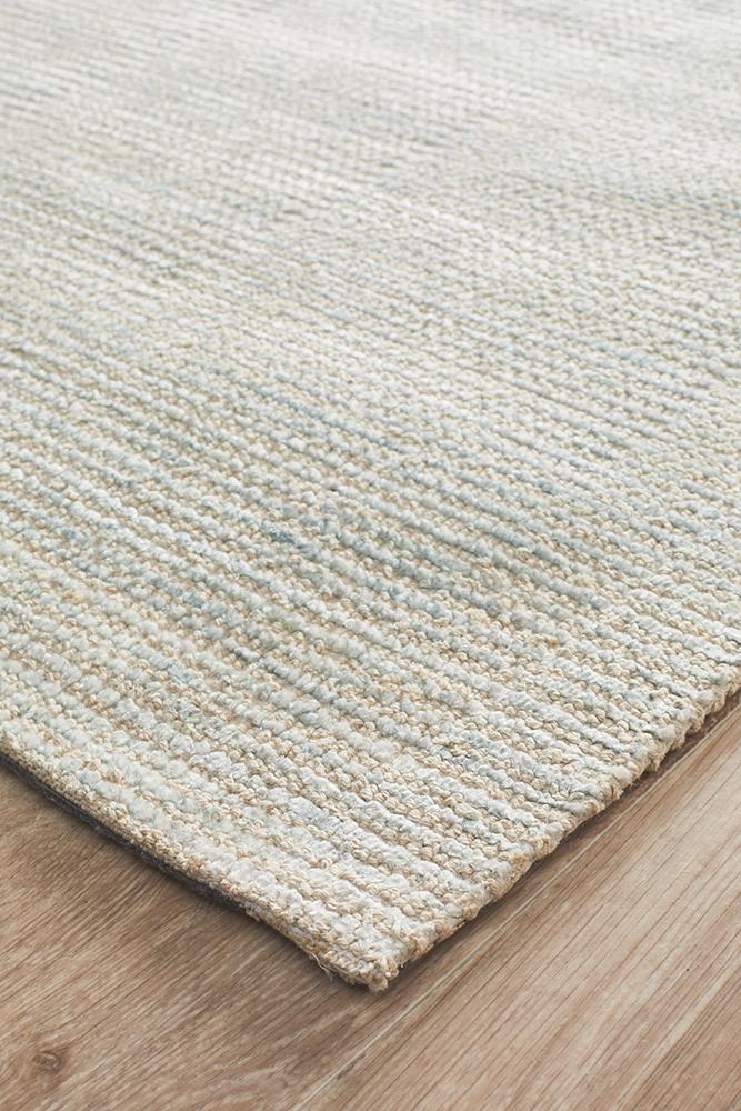 Focused image capturing the edge of the Allure Rug in Sky, emphasizing the craftsmanship and quality of its hand-loomed construction.