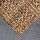 Close-up of a textured woven mat on a gray surface