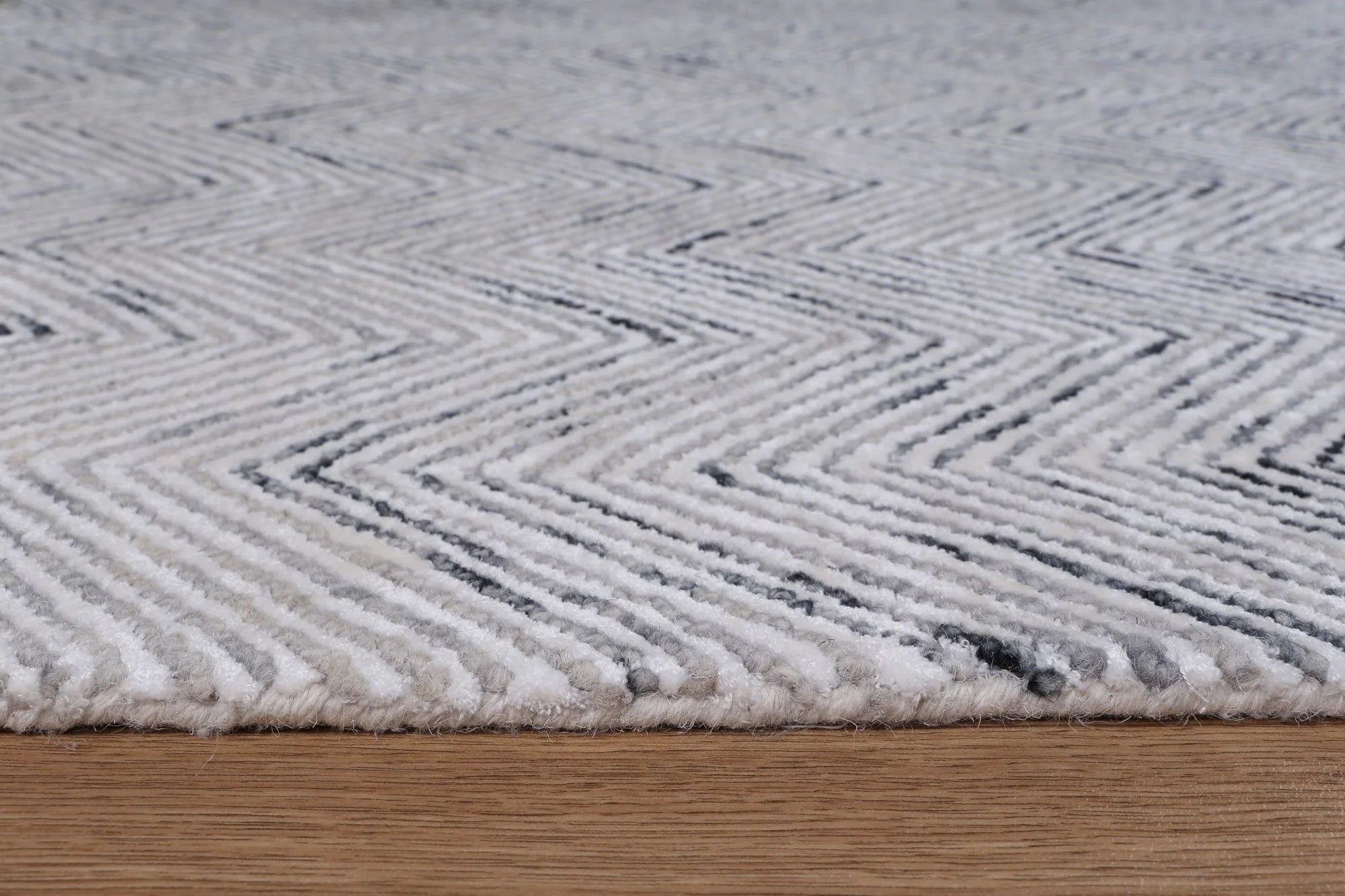 Zoomed-in view of the Astrid Rug's unique braided loop and viscose cut pile, highlighting the artisanal craftsmanship.