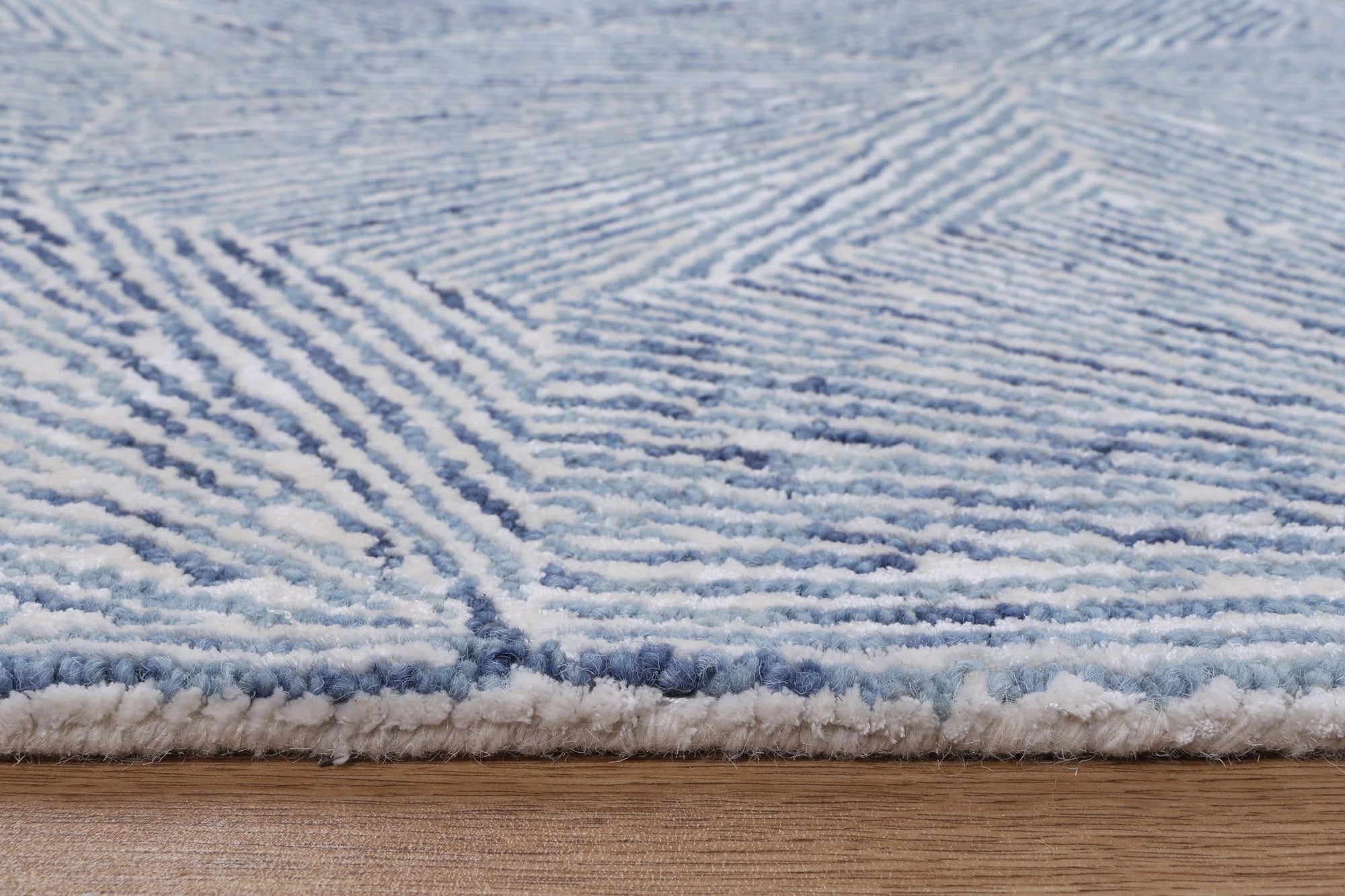 Close-up view of the Astrid Hexagon Blue Rug showing its unique hexagon pattern in shades of blue and the intricate weave texture.