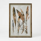 Framed botanical art print featuring watercolor-style dried leaves and small berry clusters in earthy brown, beige, and gray tones, set in a rustic wood frame against a light neutral background.