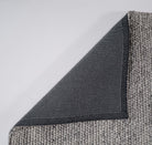 Gray textured rug corner on a white background