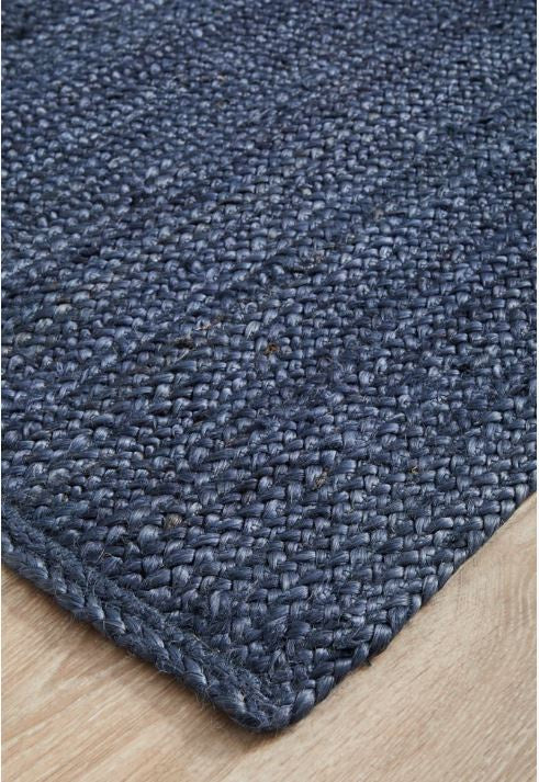 Close-up of a blue textured rug on a wooden floor
