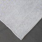 Close-up of a textured gray fabric corner on a dark background