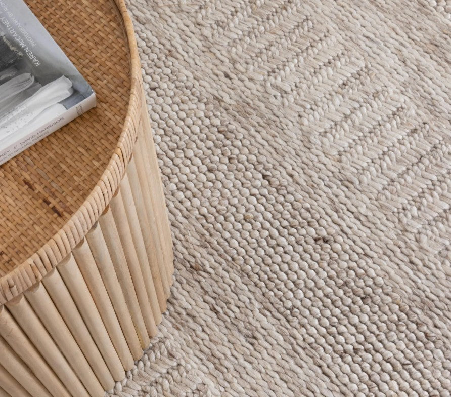 Close-up of a textured beige carpet with a woven pattern.
