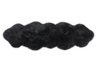 Black double sheepskin rug on a white background