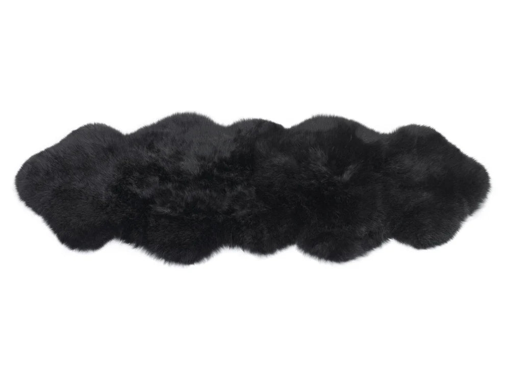 Black double sheepskin rug on a white background