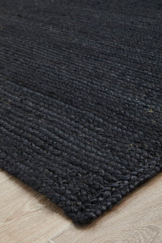 This image highlights the deep black color and organic texture of the hand-braided jute, showcasing the rug's distinctive character and quality.