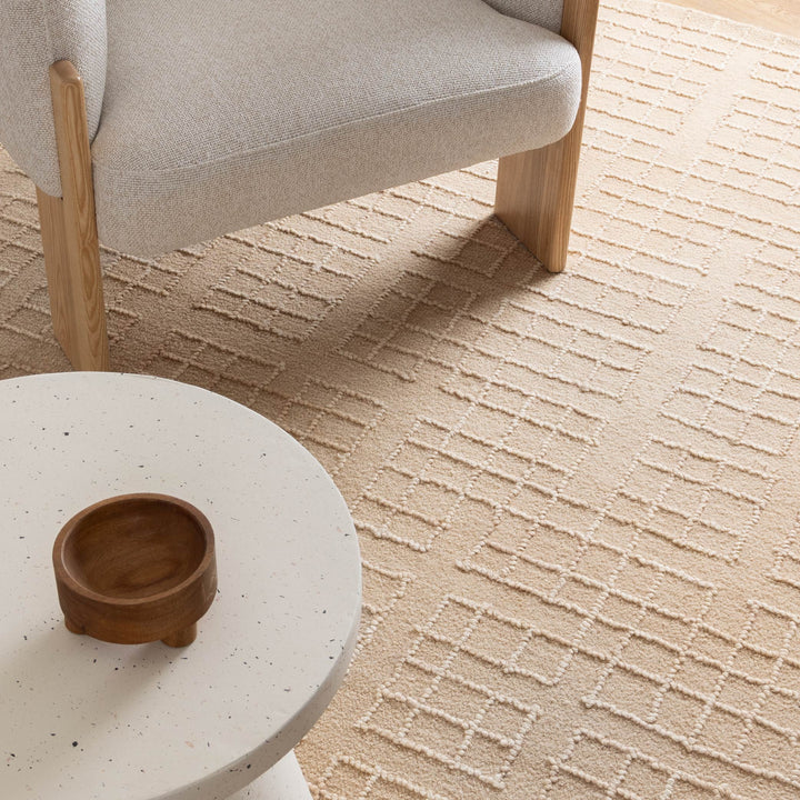 Round white table with a wooden bowl on a textured beige carpet