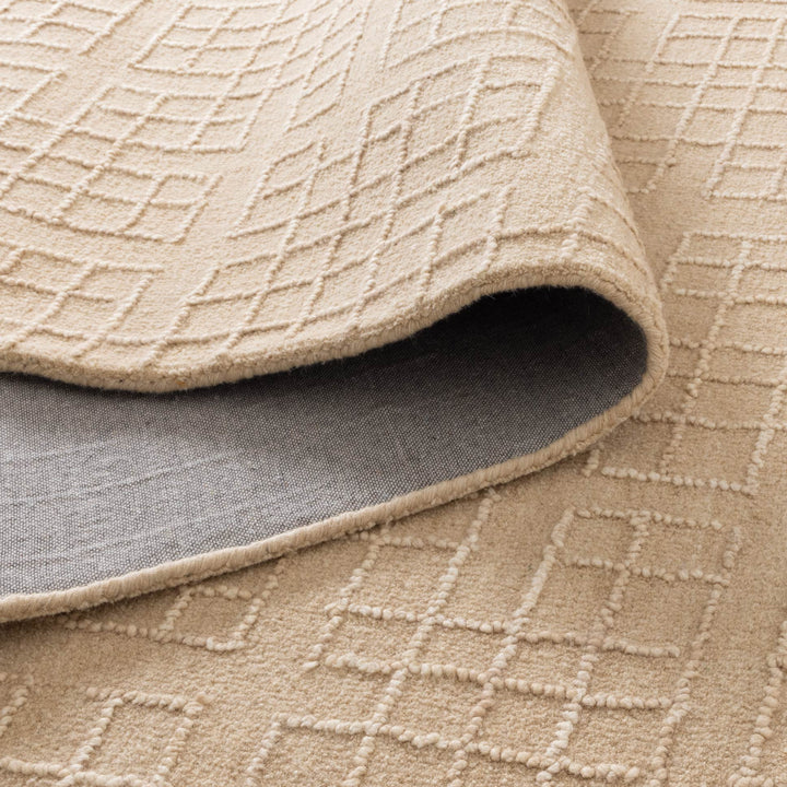 Close-up of a textured beige rug with geometric pattern