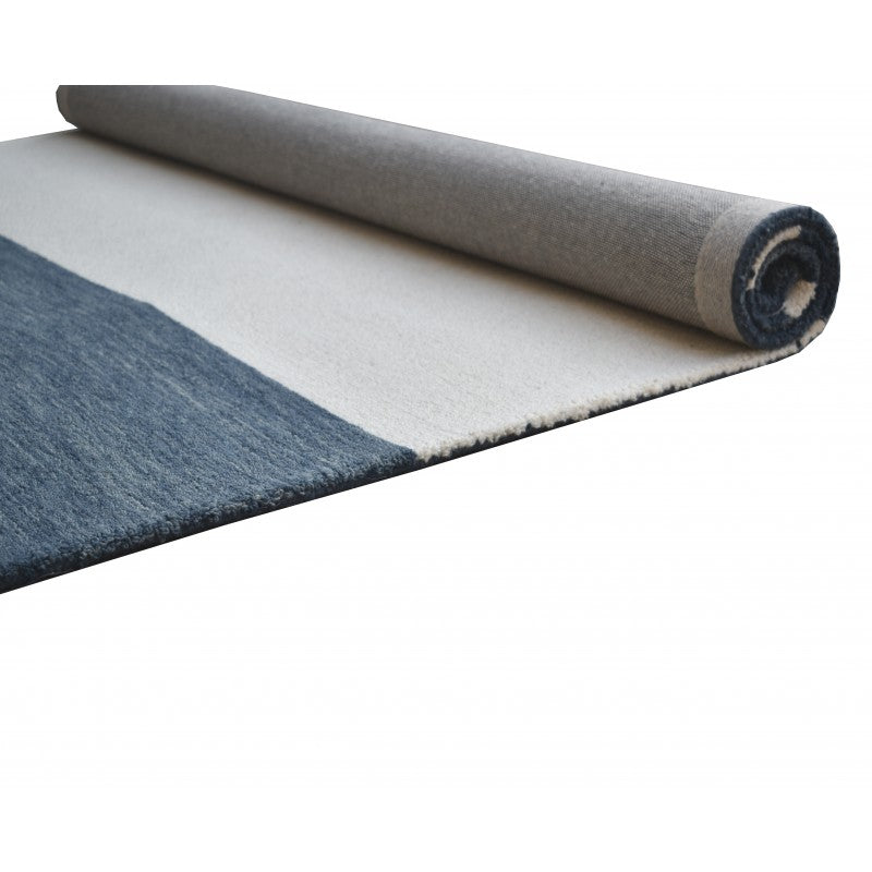 Rolled-up rug with blue and gray pattern on a white background
