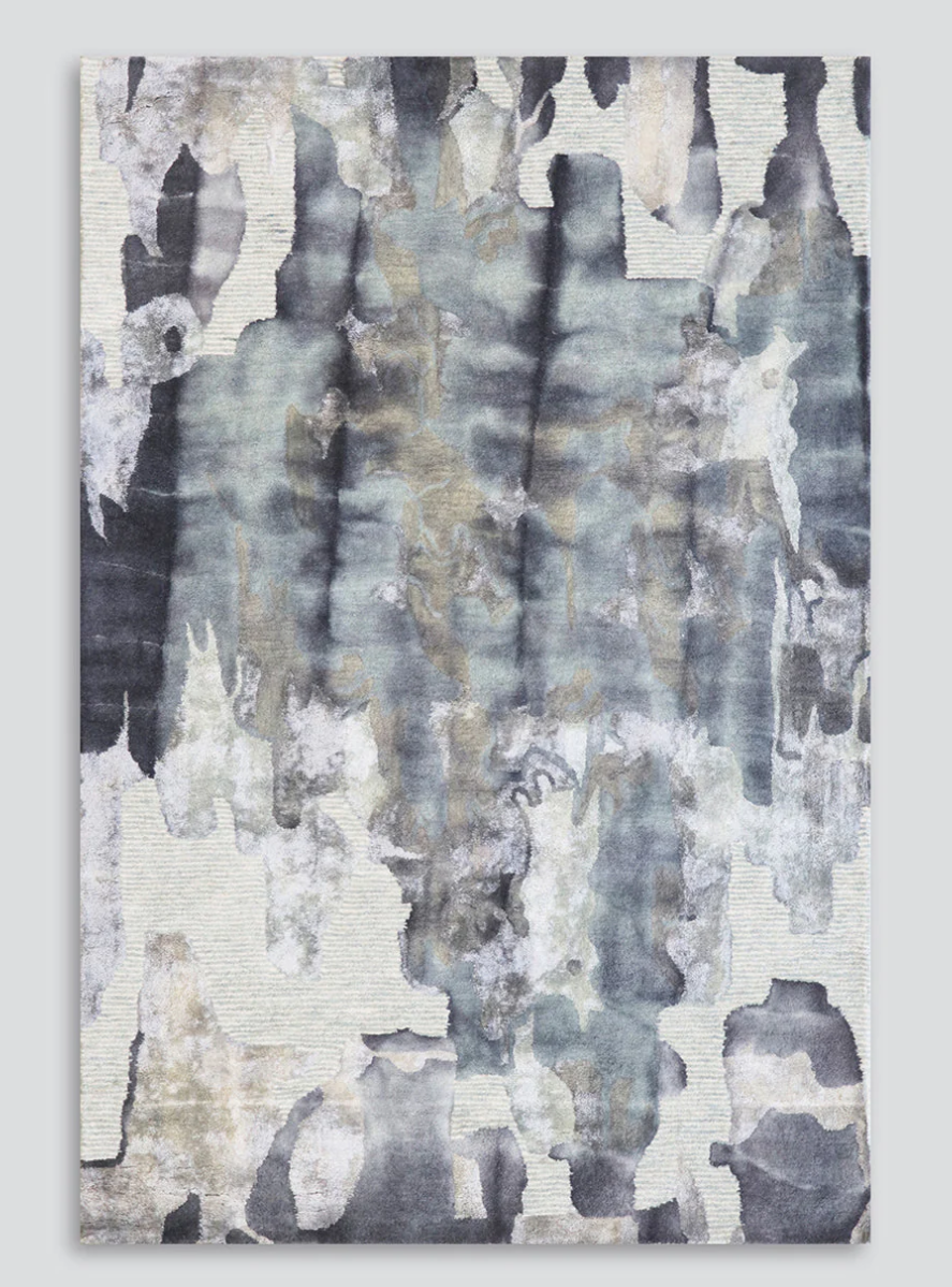 An abstract rectangular wall art piece with a textured, watercolor-like design in muted gray, slate blue, beige, and off-white tones, shown against a light gray background.