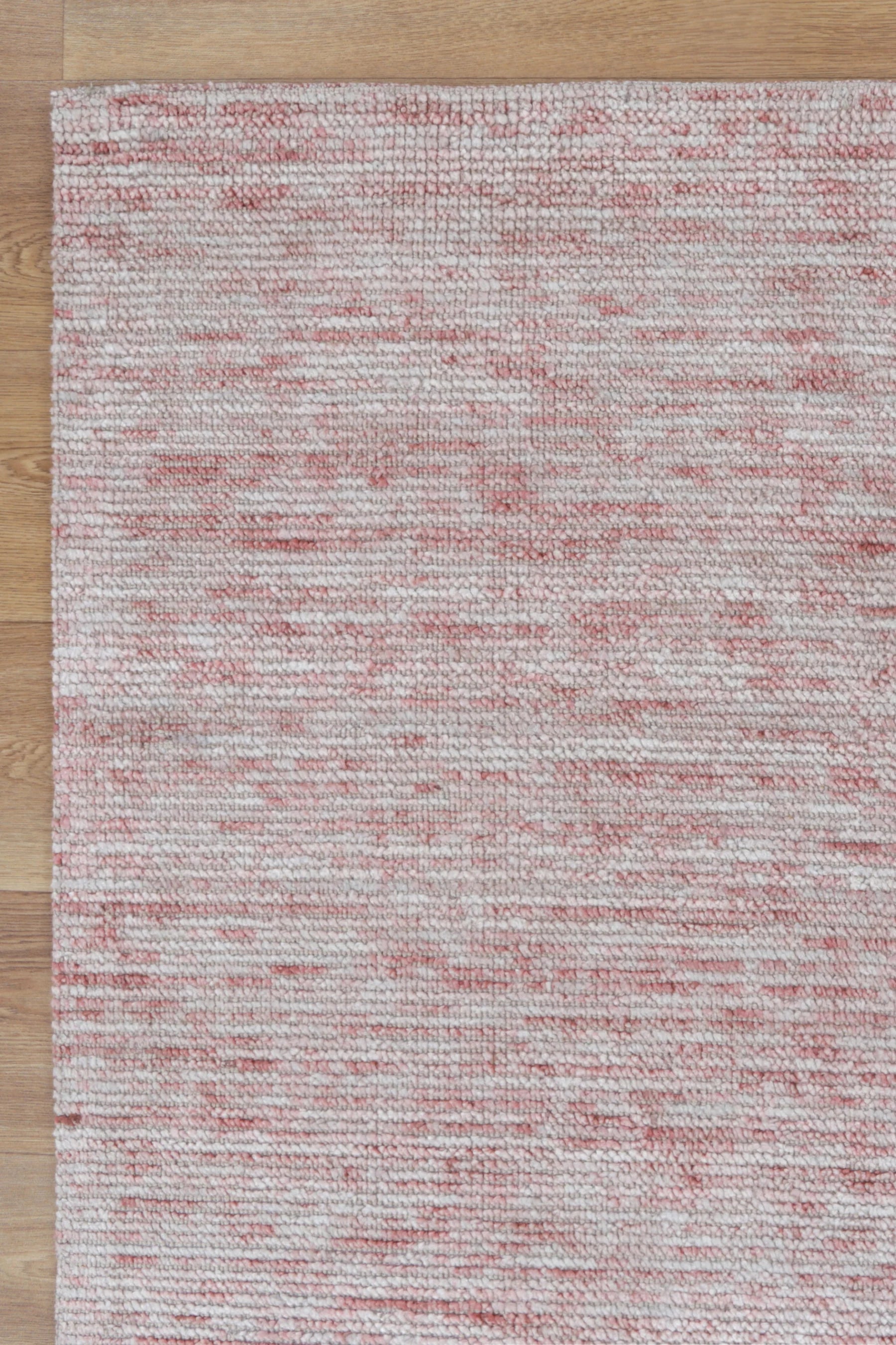 Textured red and gray area rug on a wooden floor