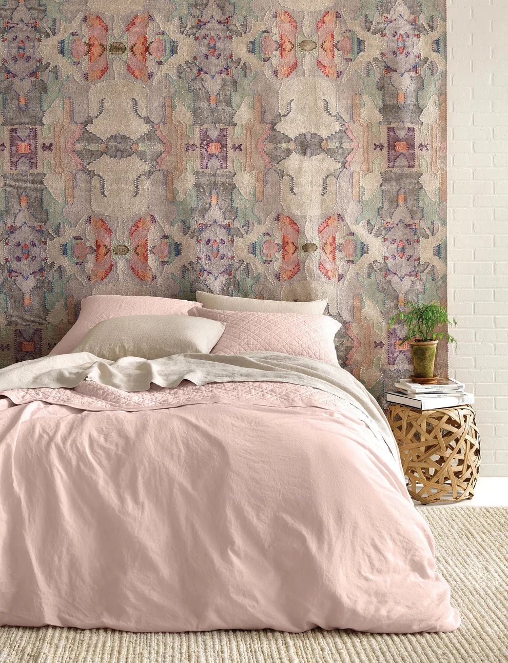 Bedroom with pink bedding and patterned wallpaper