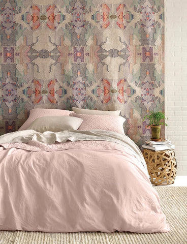 Bedroom with pink bedding and patterned wallpaper