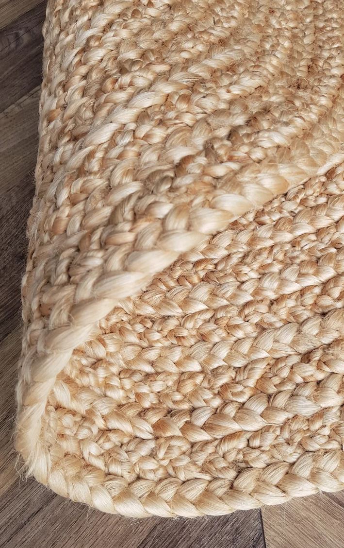 Close-up of a braided beige rug on a wooden floor