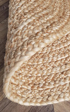 Close-up of a braided beige rug on a wooden floor