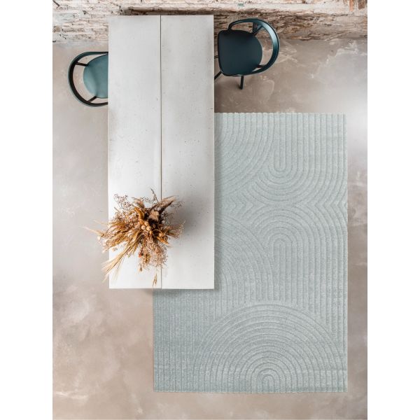 Textured rug with geometric pattern on a concrete floor