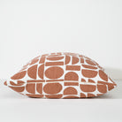 A square throw pillow with a terracotta rust and white geometric pattern, photographed against a clean white background.