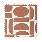 A square fabric or material swatch with scalloped edges, featuring a terracotta rust and white geometric pattern of semi-circles, arcs, and blocks.