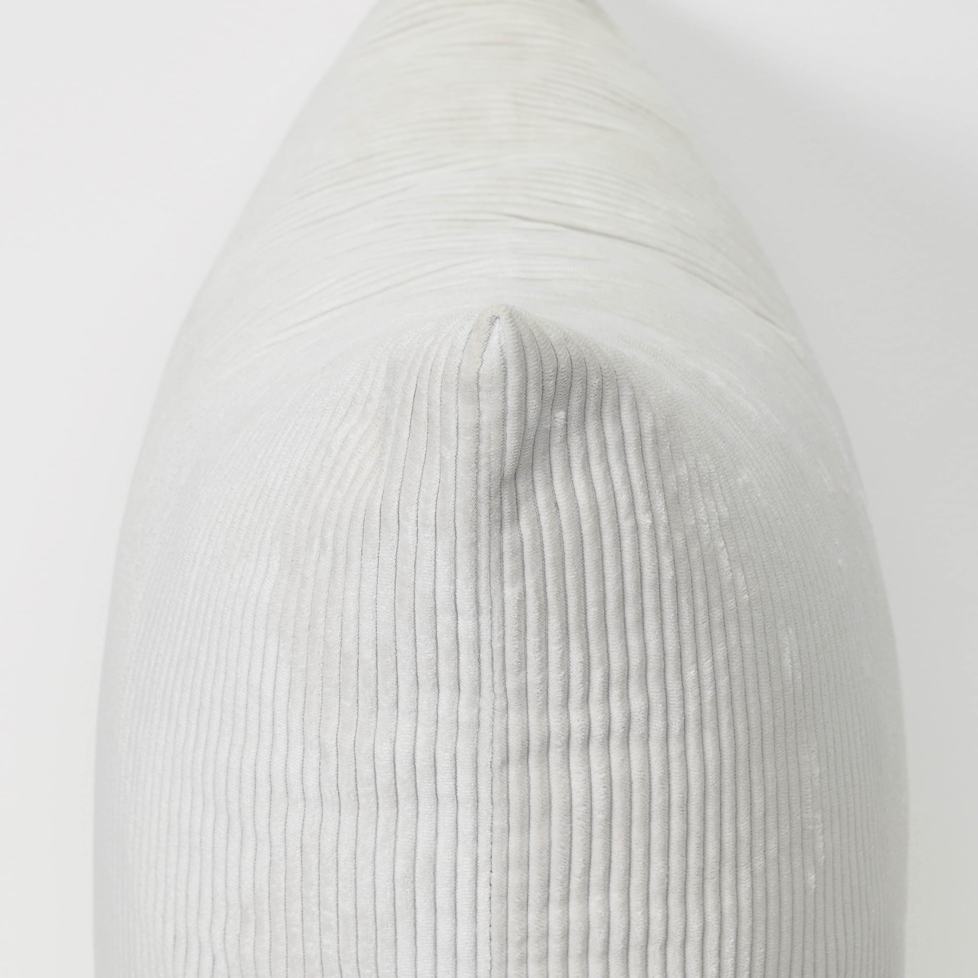 A close-up of a light gray ribbed fabric cushion or pillow against a plain white background.