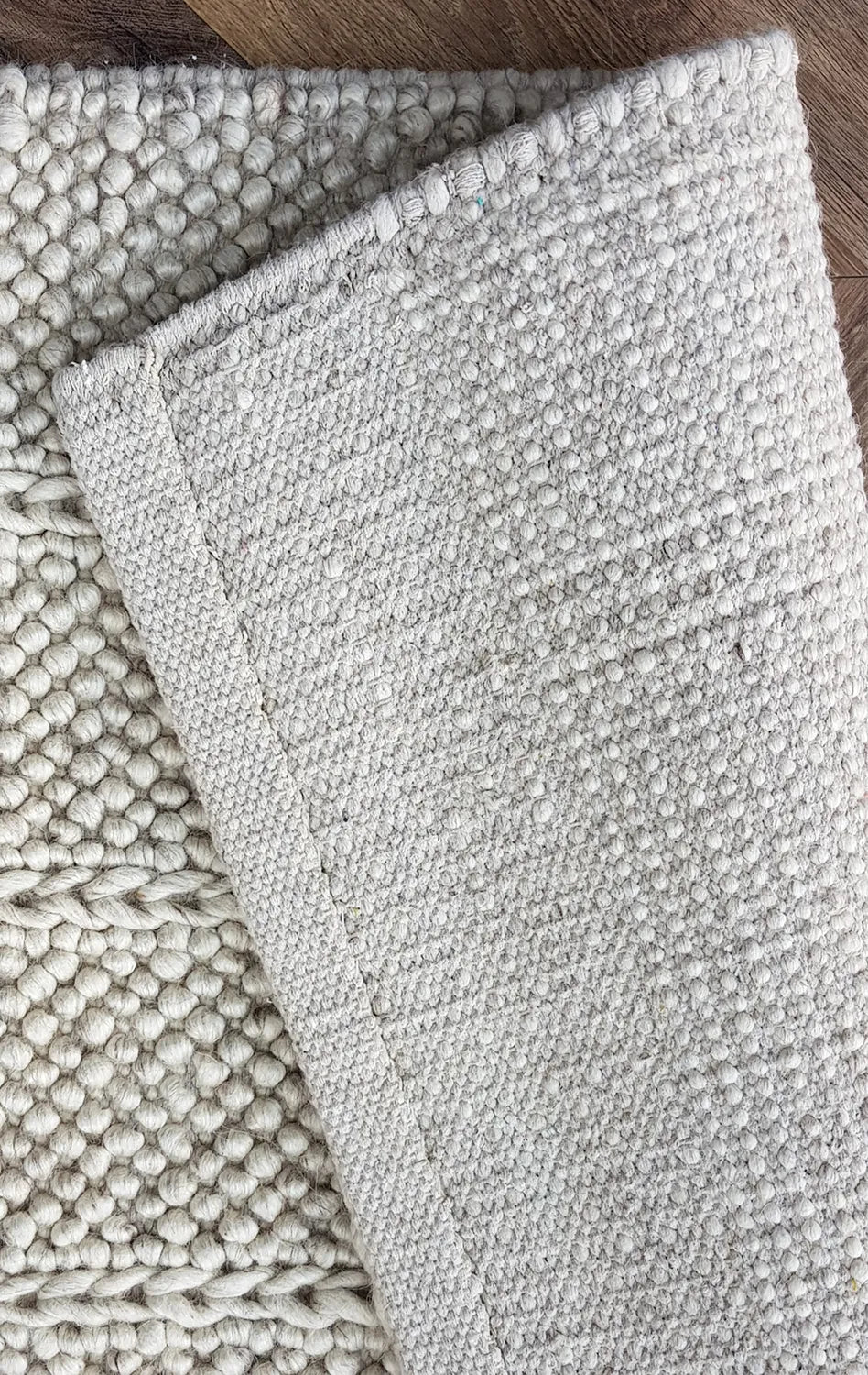 Textured gray rug on a wooden floor