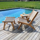 Wooden outdoor furniture set with a chair, ottoman, and small table by a pool.
