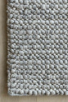 Textured gray rug with a pattern on a wooden floor