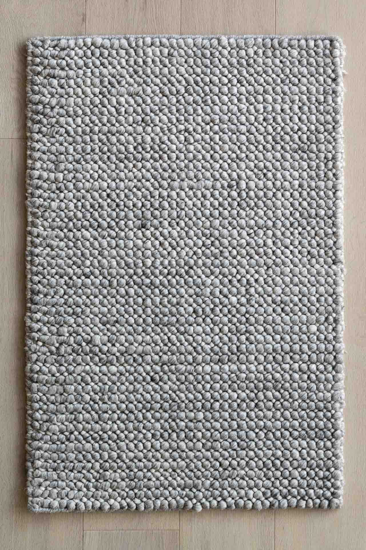 Textured gray rug on a wooden floor